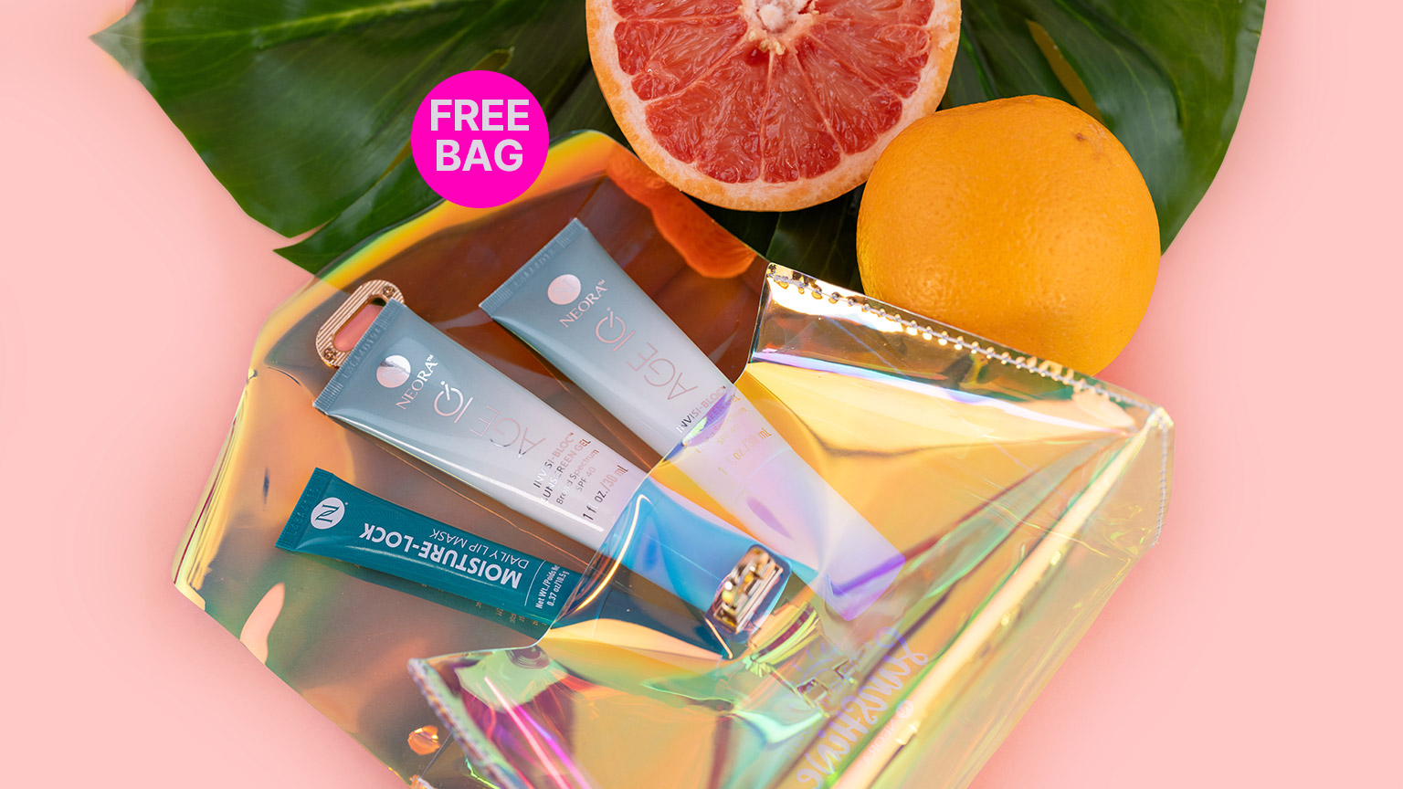 Neora’s Summer Skin Essentials Set, which includes two Age IQ Invisi-Bloc SPF40 Sunscreen Gels and a Moisture-Lock Lip Mask laying inside of a FREE Holographic Travel Bag next to a leaf and some grapefruit